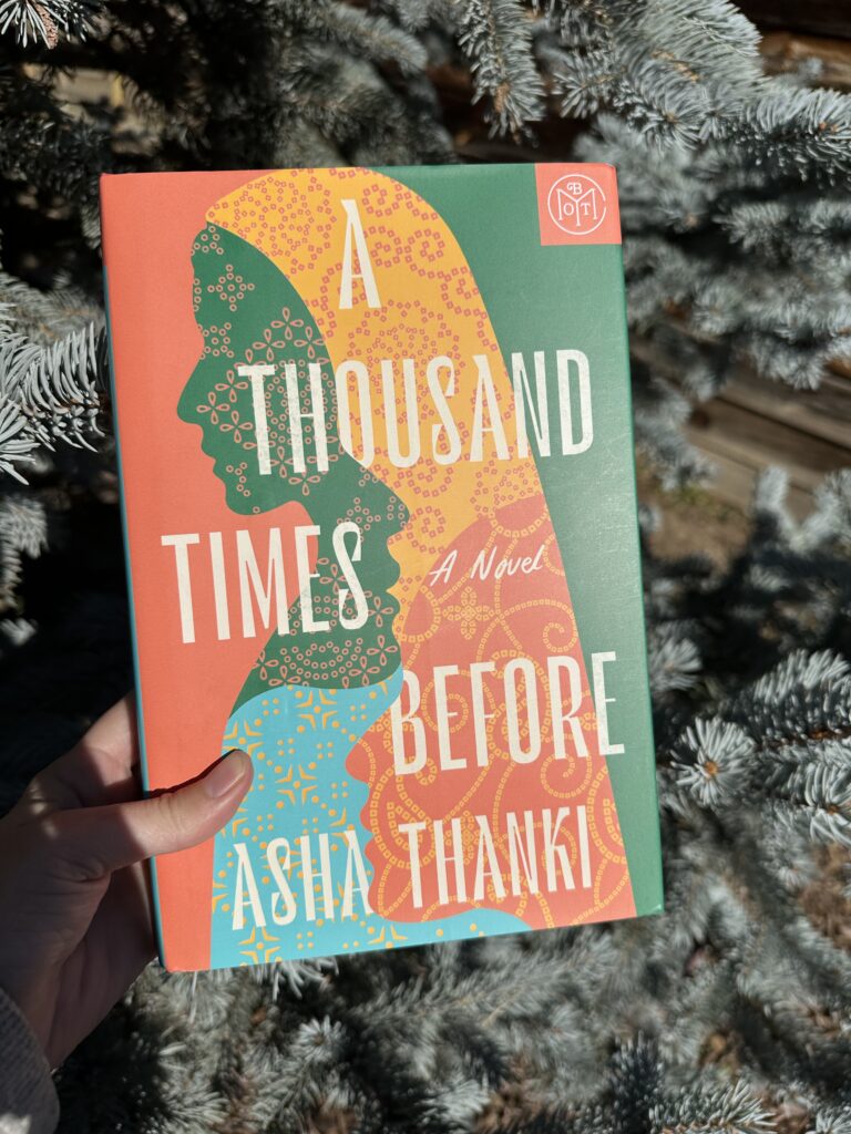 The cover of A Thousand Times Before by Asha Thanki shows a tapestry of women's profile's