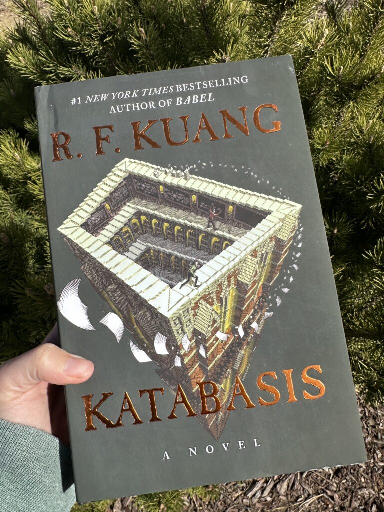 The cover of Katabasis by R.F. Kuang shows two figures running along an Escher staircase that continues to infinity.