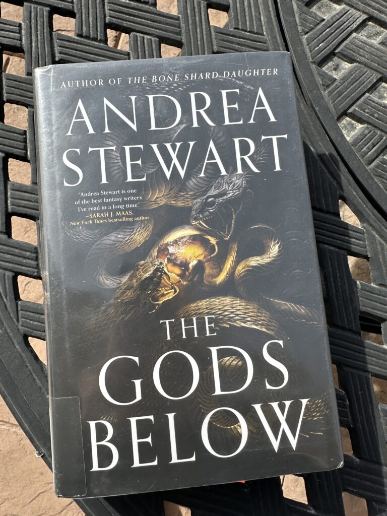The cover of The Gods Below by Andrea Stewart shows too snakes snarling at each other