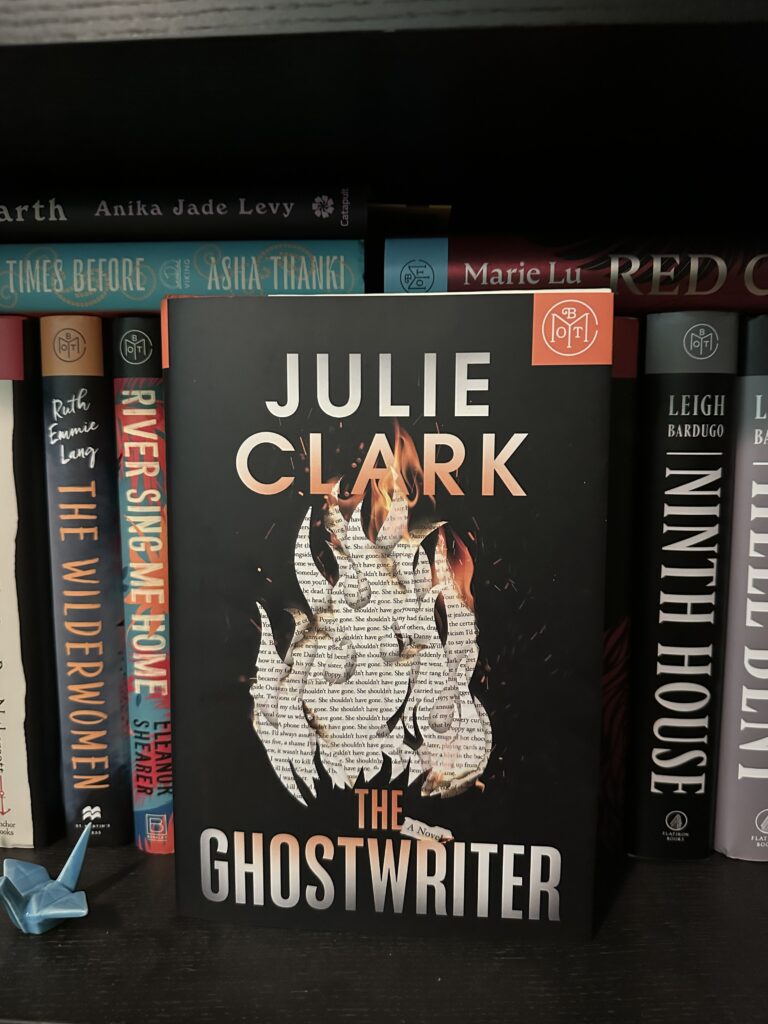 The cover of The Ghostwriter by Julie Clark shows a fire made of pages of text on a black background